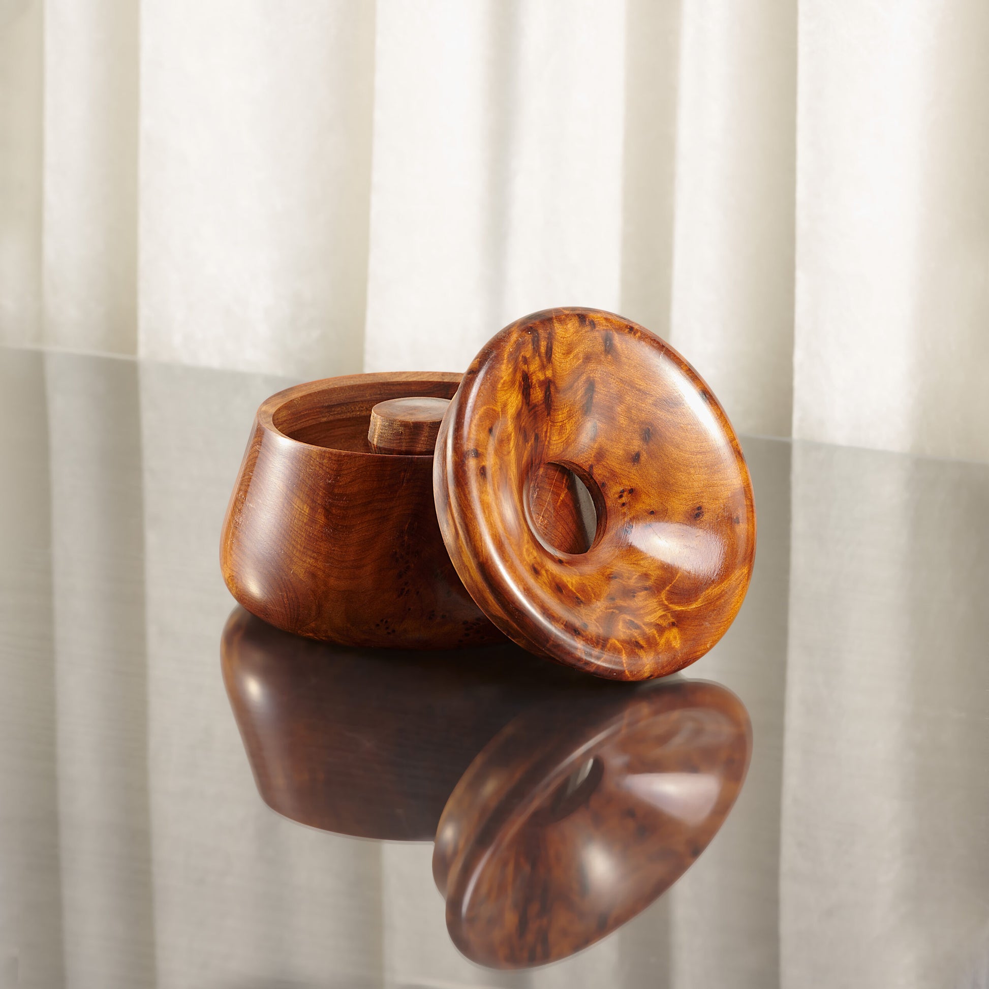 thuya wood ashtray with lid, open on a glossy surface