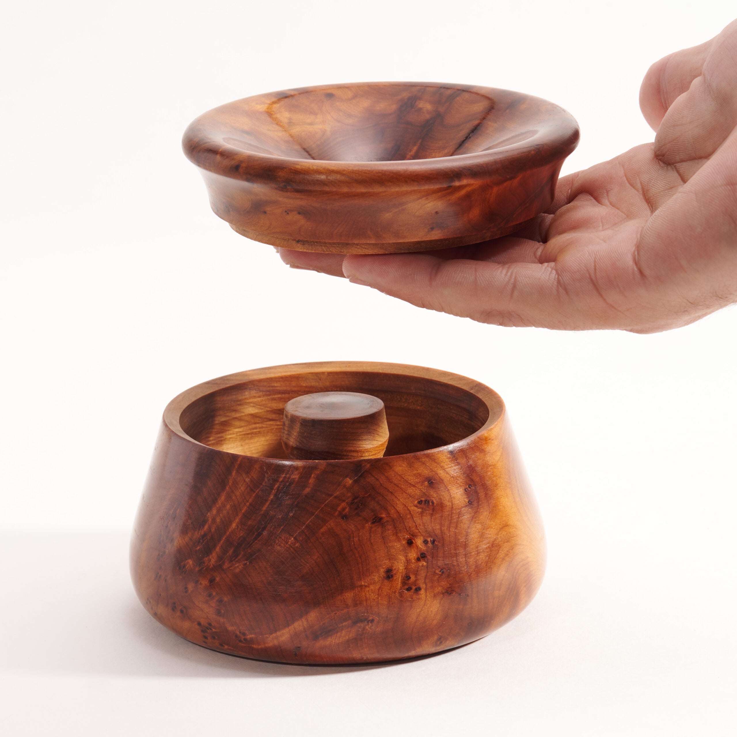 Wooden bowl with a hand holding it on a white background