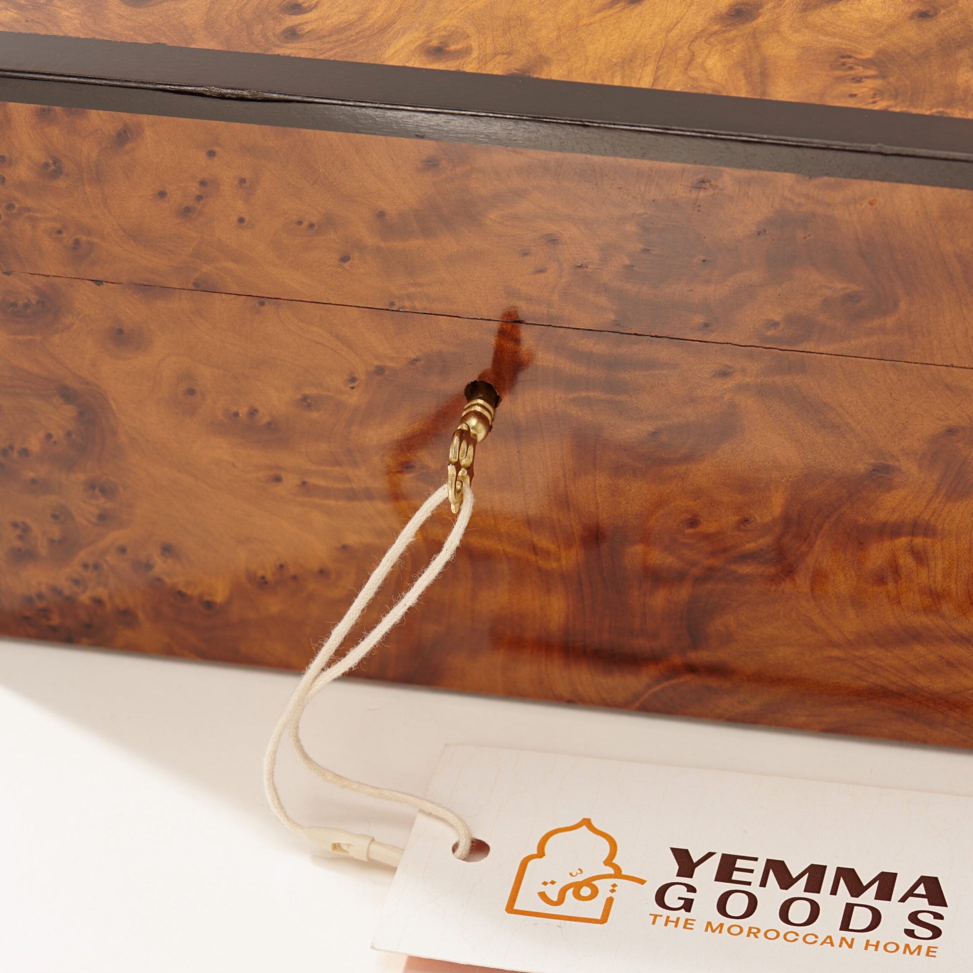 front part of a thuya wooden box AKAL showing the key inserted in the lock, the box features magical burl grain paterns
