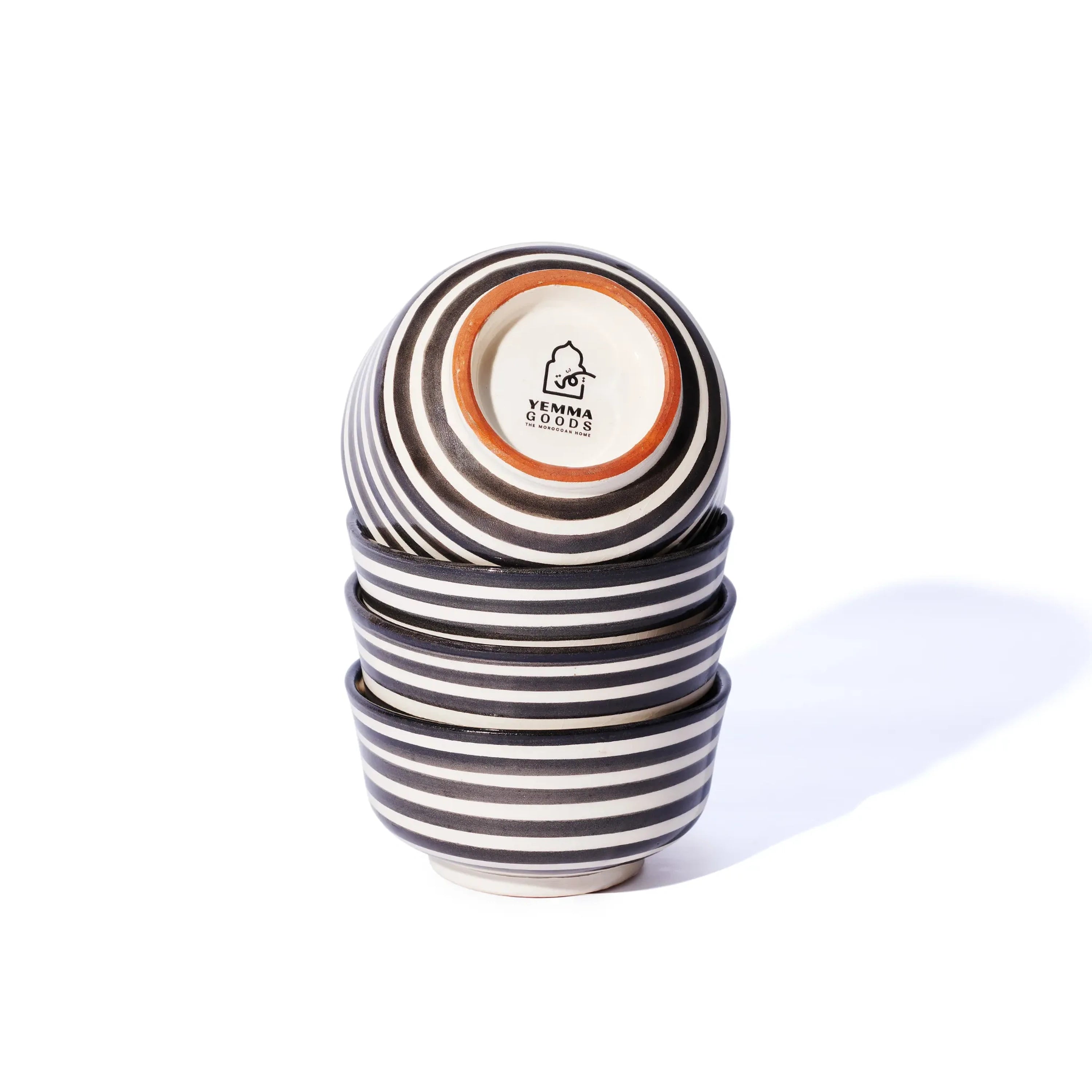 set of 4 ceramic striped black and white bowls stacked vertically, with the top one showing the yemma goods logo on the bottom