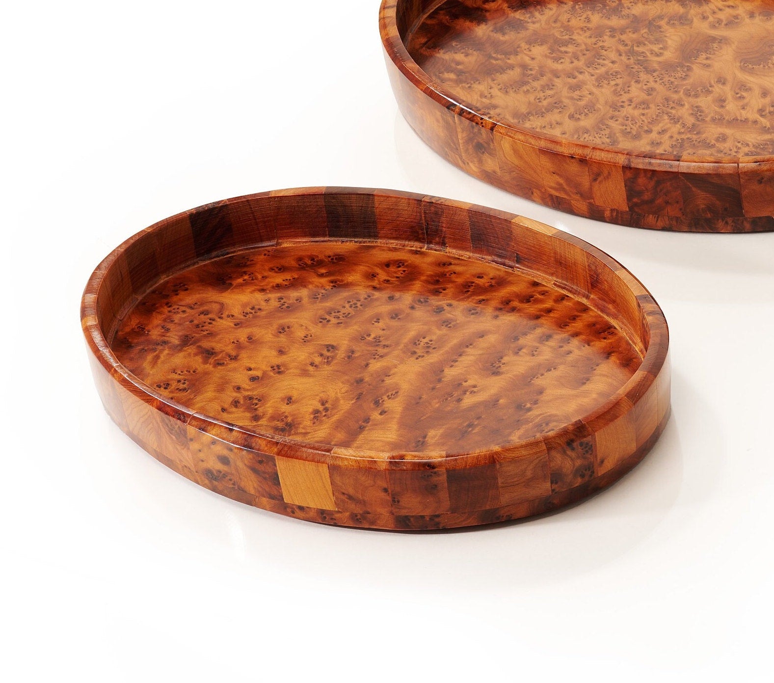 Two wooden trays with a burl pattern on a white background