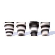 Four black and white striped ceramic tumblers on a white background