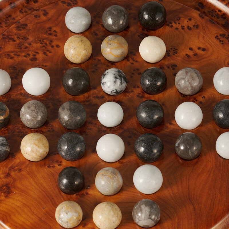 close up on thuya wood solitaire game with marble balls